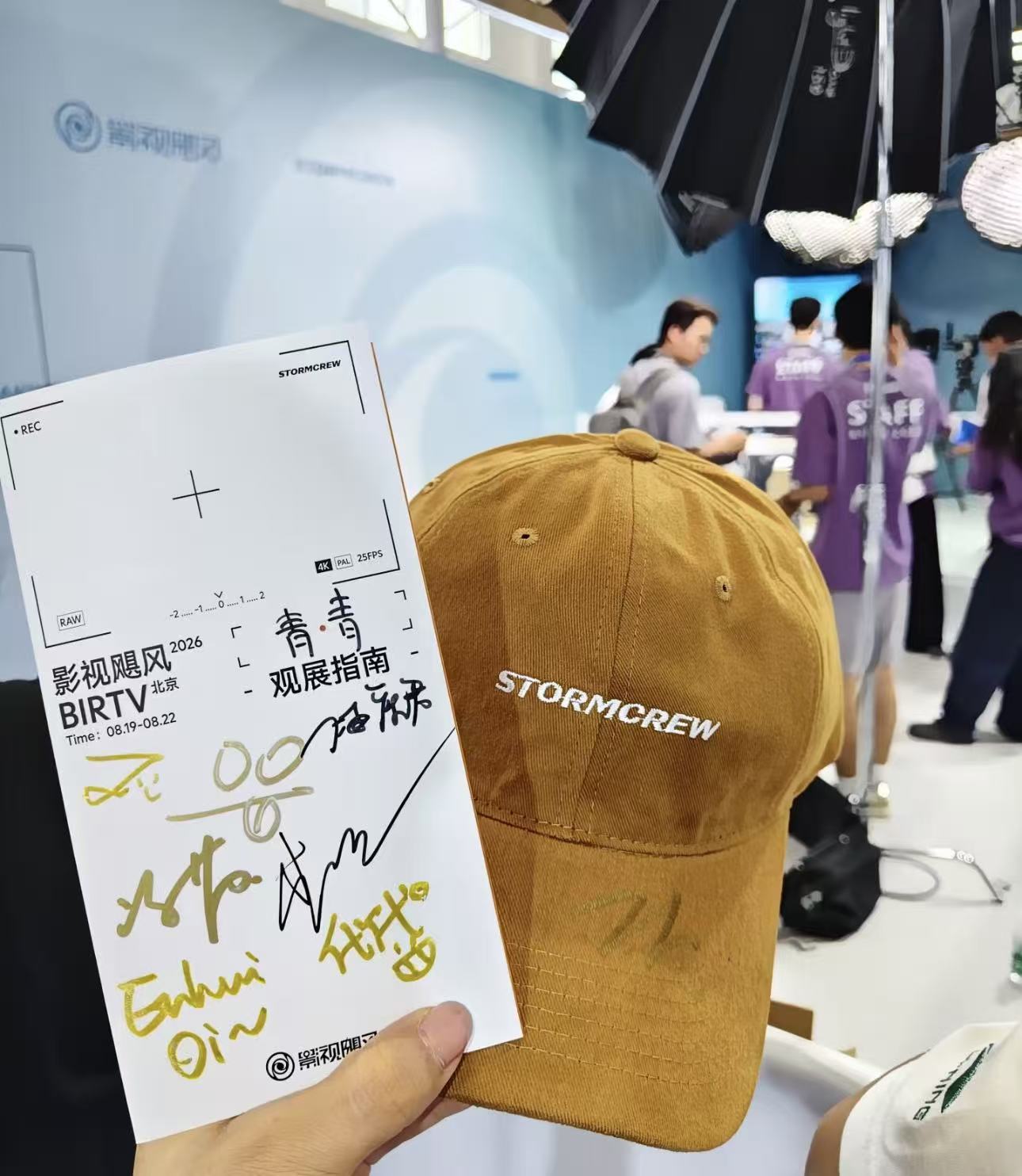 签名后的 BIRTV 观展手册与 STORMCREW 帽子一起出现在观众的现场照片中